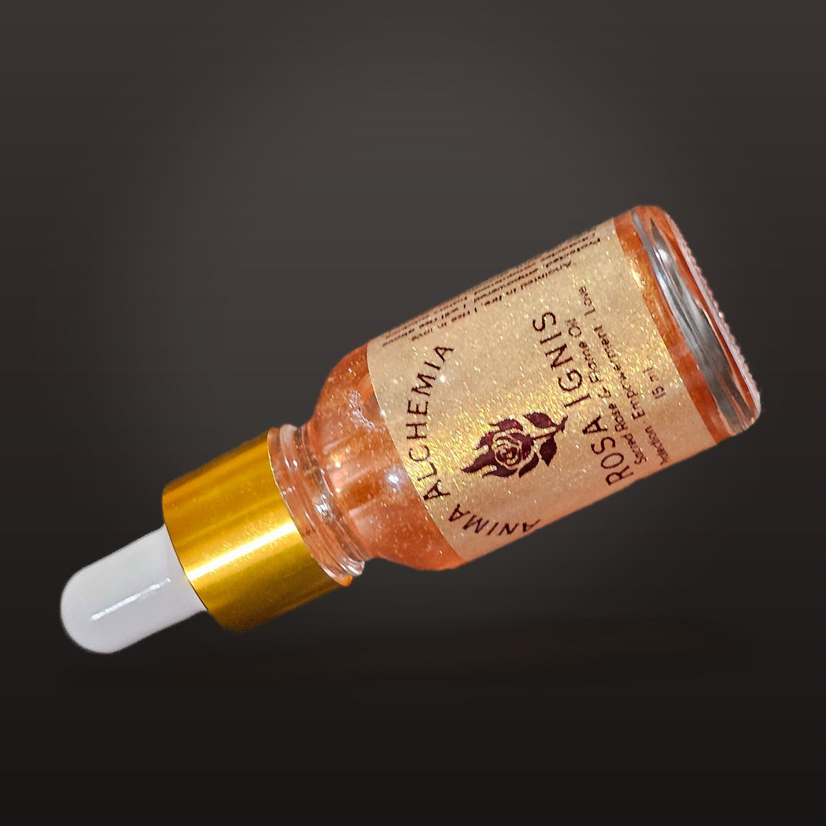 Rosa Ignis ritual oil lying on a dark background, showing the copper-red shimmer in the oil
